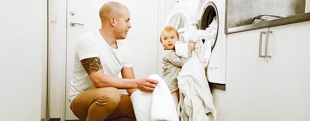 Far og barn vasker vasketøj.